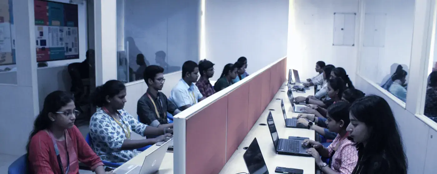 Interns working at computers in a long lab